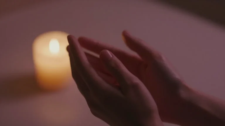 Two hands gently clasped in soft candlelight representing tender intimate connection after ostomy